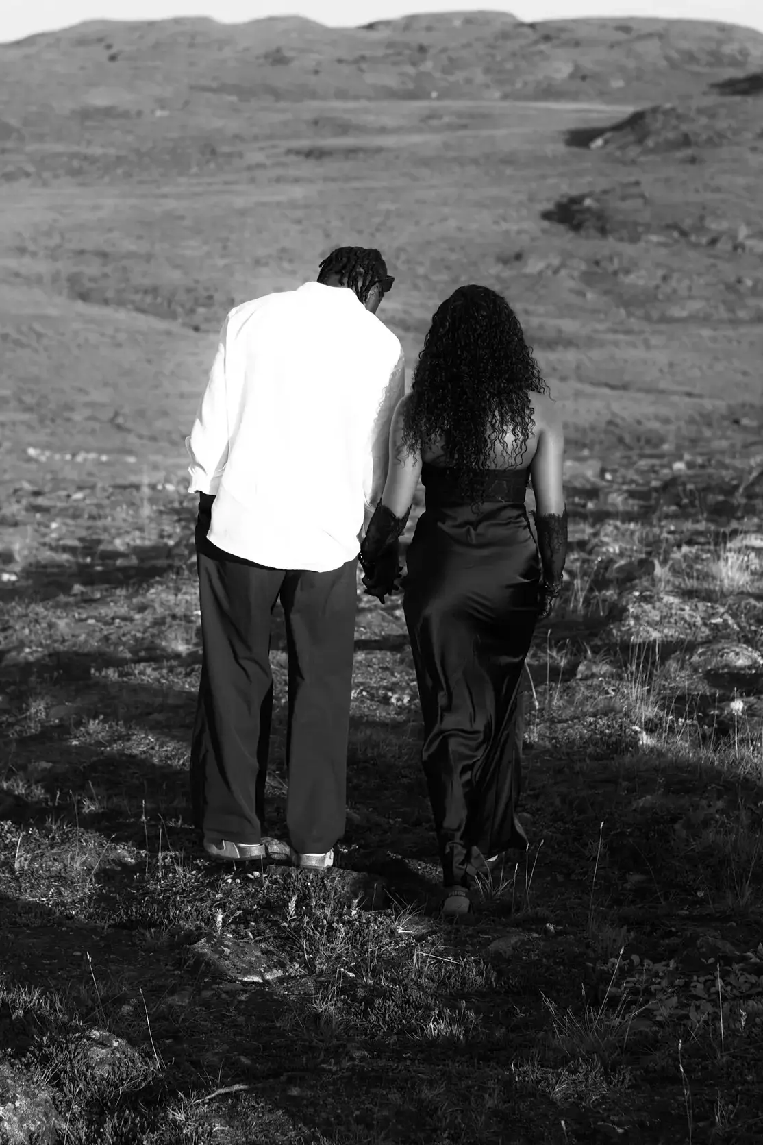 Temiloluwa and Olugbenga embracing on a lawn by the sea in Cabo, black and white